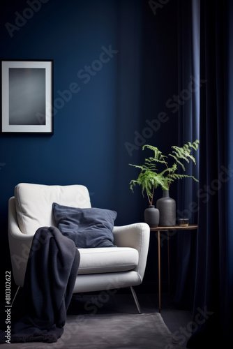 Cozy reading nook with deep blue wall color, a comfy chair and a plant