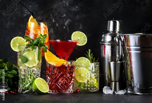 Assorted cocktails and mixology tools on dark backdrop