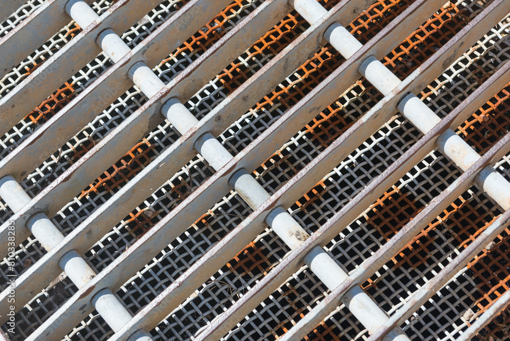 A metal grate with white and black stripes A metal grate with white and black stripes