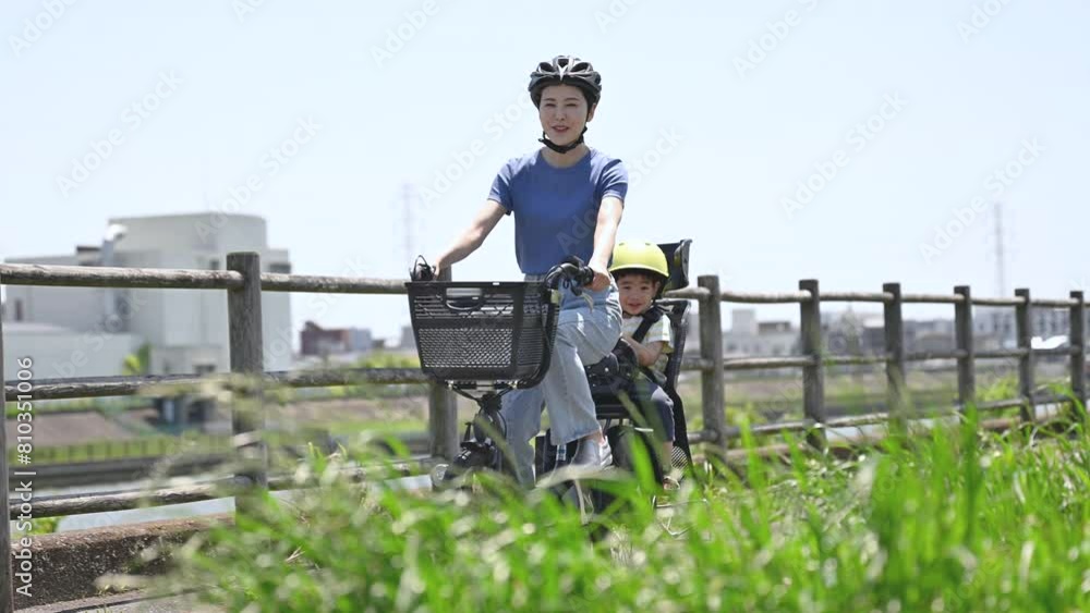 春夏の青空の綺麗な道を自転車に乗るママと子供 ママチャリでお出かけや出勤 全身の動画 春夏の青空の綺麗な道を自転車に乗るママと子供 ママチャリでお出かけや出勤 全身の動画