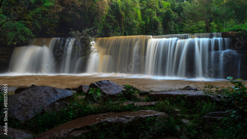 Long exposure of a tranquil waterfall surrounded by lush greenery