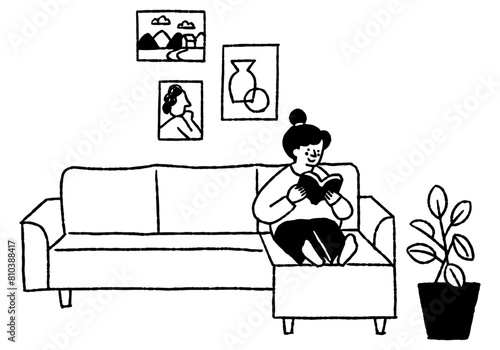 Woman reading a book on the living room sofa_2