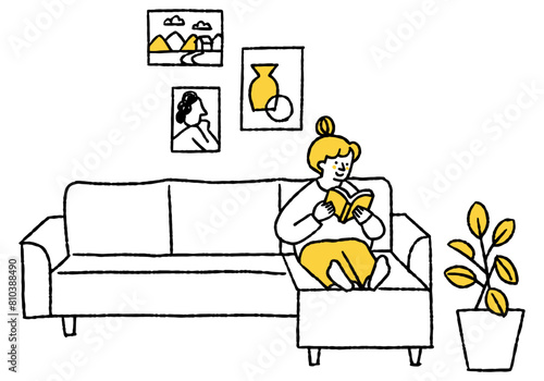 Woman reading a book on the living room sofa