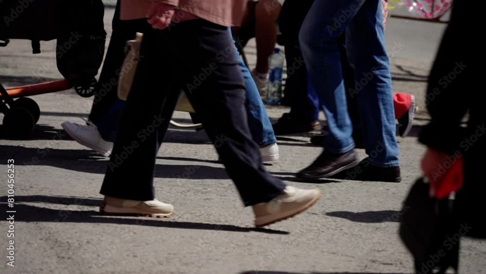 Street-level view of busy pedestrians' feet and strollers on a bustling urban crosswalk Street-level view of busy pedestrians' feet and strollers on a bustling urban crosswalk