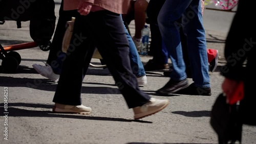 Street-level view of busy pedestrians' feet and strollers on a bustling urban crosswalk