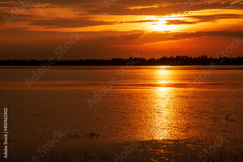 Tropical amazing dramatic golden sky on sunset over scenic river lake seascape ocean. Silhouette tranquil season wilderness serene landscape. Tranquil lake countryside sunrise seaside reflection © aFotostock