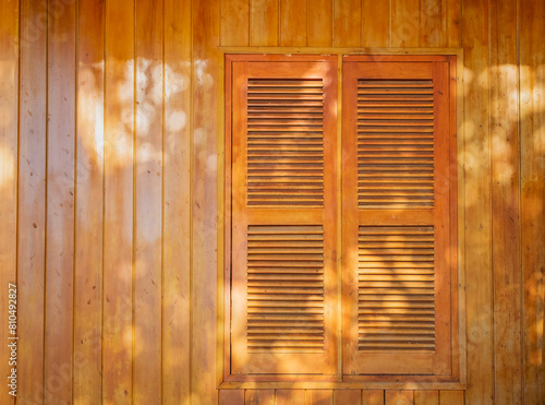 Brown Wooden shutters on a wooden wall background.