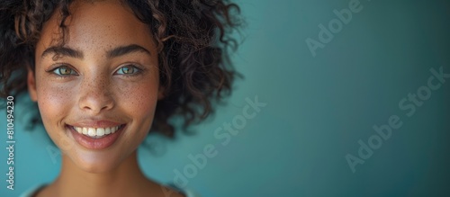 portrait of beautiful smiling woman with short wavy blonde hair wearing pastel blue sweatshirt, isolated on solid color background