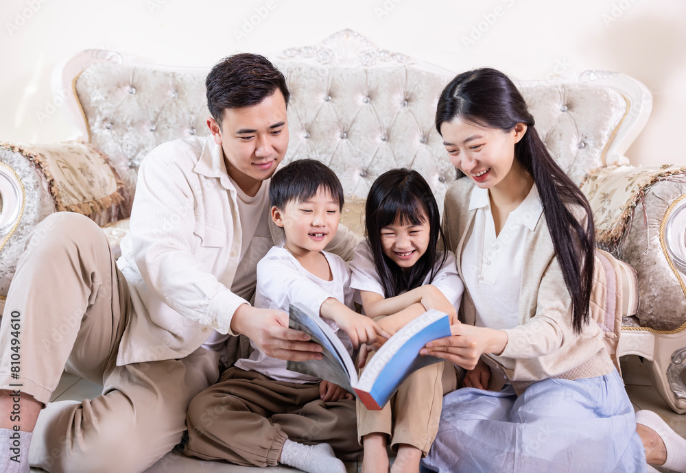 A family of four reading and playing together in the living room A family of four reading and playing together in the living room