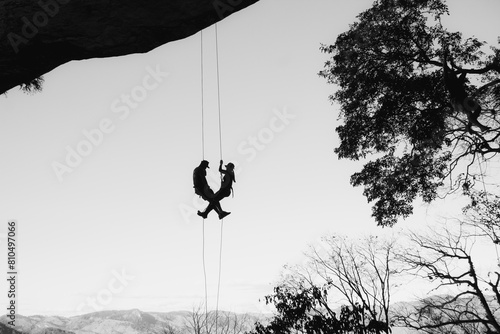 Valokuva Silhouette of a couple abseiling