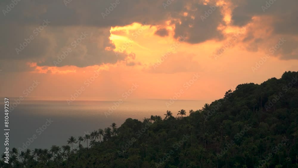 Sunlight pierces through clouds above ocean, painting the sky in a warm glow Sunlight pierces through clouds above ocean, painting the sky in a warm glow