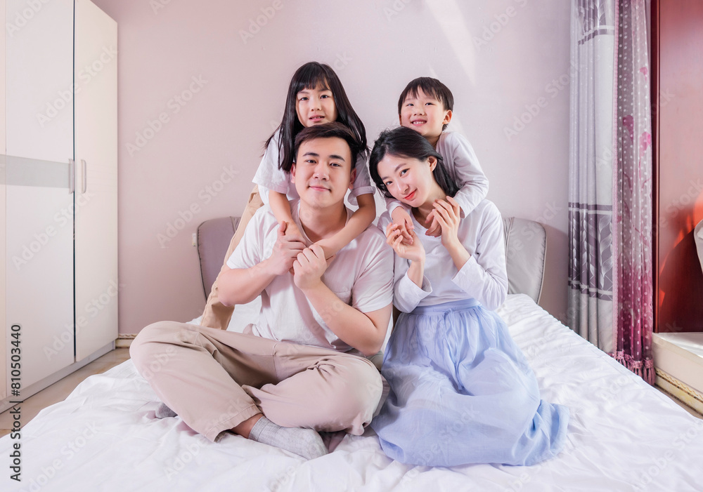 A family of four in bed in the bedroom