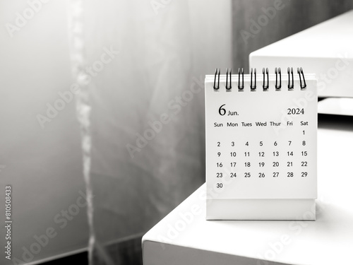 A June 2024 calendar desk for the organizer to plan and reminder on table in white room background with copy space. White small table calendar with the date page of the sixth month.