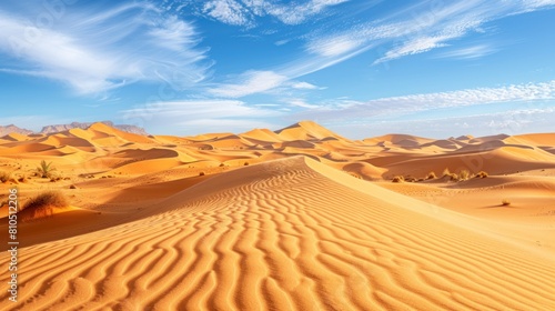 beautiful view of the desert. The bright yellow sand forms wide  smooth hills  with bright blue skies and white clouds adorning them