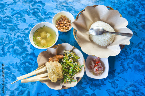 Nasi Campur Bali, a Popular Balinese Dish of Steamed Rice with Variety of Side Dishes. Indonesian Bali traditional food.