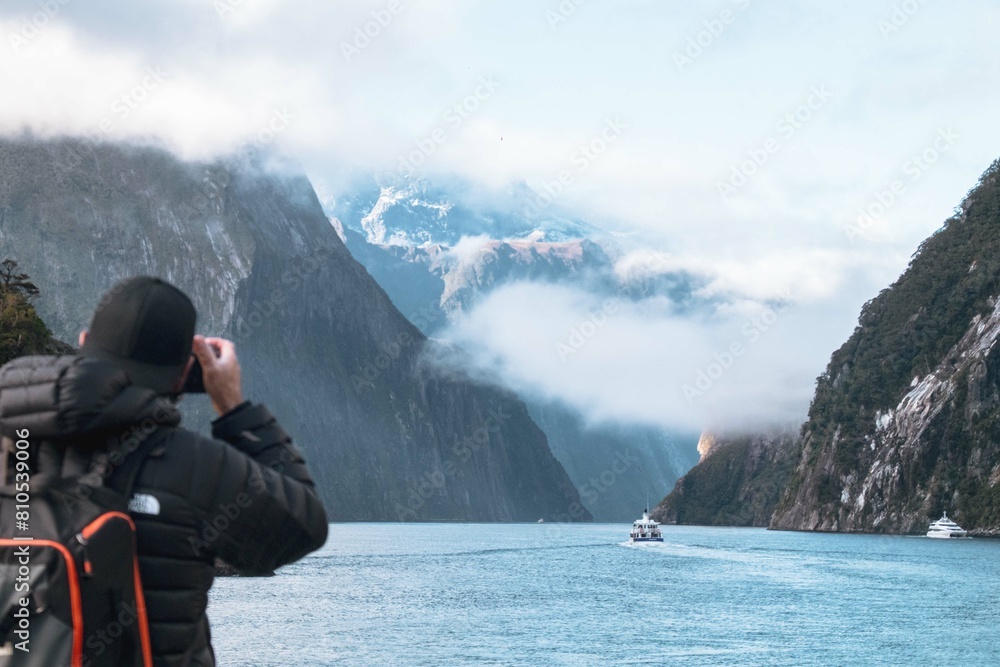 A man photographing a landscape in a place surrounded by mountains A man photographing a landscape in a place surrounded by mountains