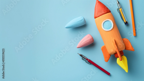 Rocket made of plasticine and stationery on light background