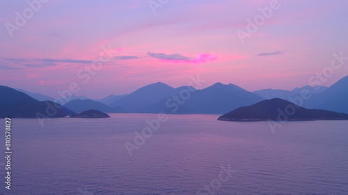   A serene body of water nestled among mountains  framed by a pink and blue sky  with the sun at its center