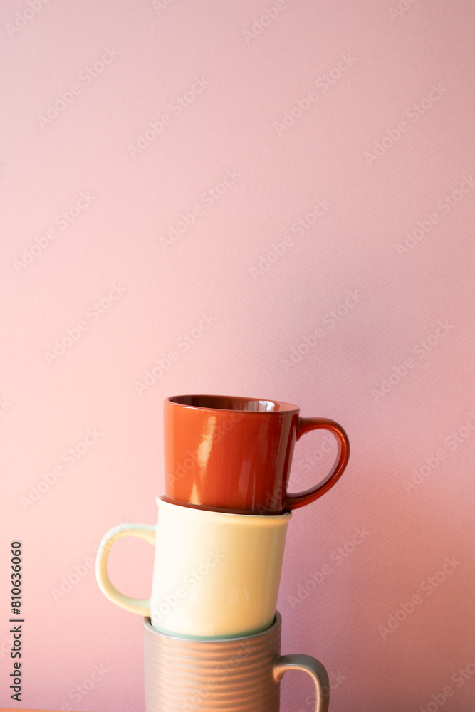 Stack of mug cups with pink wall background