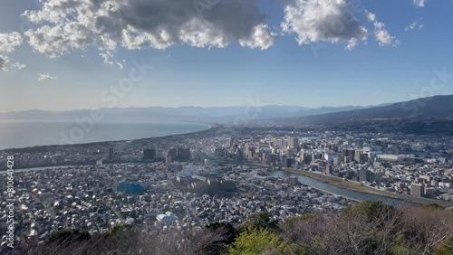 NUMAZU, SHIZUOKA, JAPAN - MARCH 2024 : Aerial high angle view of cityscape of Numazu city, Mount Fuji and Suruga bay in daytime. photo