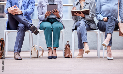 Business people, waiting room and interview for recruiting with career opportunity, writing and we are hiring. Queue, tablet and group sitting in office for hr meeting with job search and updating cv