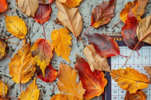 A calendar covered in autumn leaves  blending the concepts of seasonal change with the passage of time.