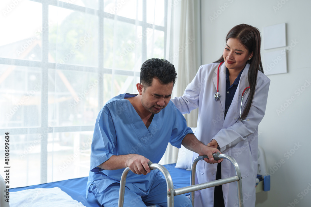 Physical therapist helps a male patient use a walker to practice walking. Support yourself from recovery from sore legs and ankles. Physical therapy service concept. Physical therapist helps a male patient use a walker to practice walking. Support yourself from recovery from sore legs and ankles. Physical therapy service concept.