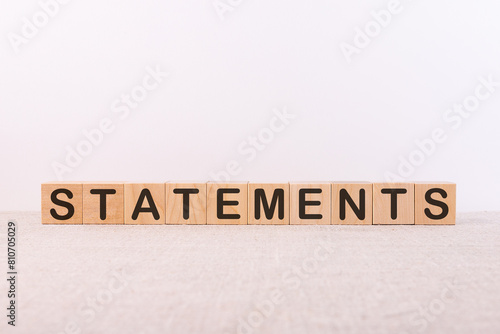 STATEMENTS word concept written on wooden cubes lying on a light table and light background.
