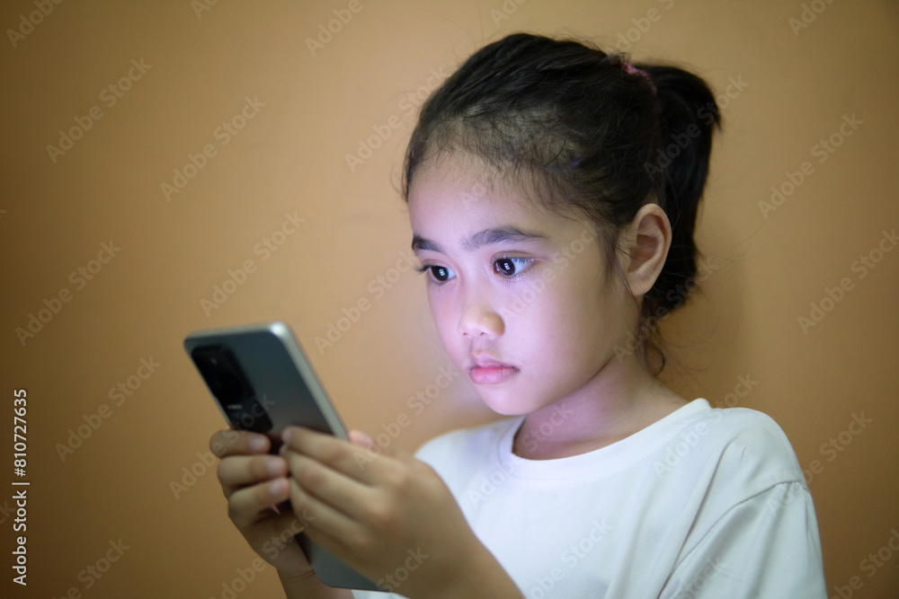 Selective focus image of Asian girl using smartphone in the dark room. Copy space for text. Smartphone addiction, bad habit concept. Selective focus image of Asian girl using smartphone in the dark room. Copy space for text. Smartphone addiction, bad habit concept.