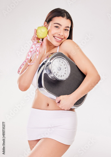 Portrait  measuring tape or happy woman with apple or scale for healthy snack  nutrition diet or digestion benefits. Smile  lose weight and fitness model with fruits in studio on white background