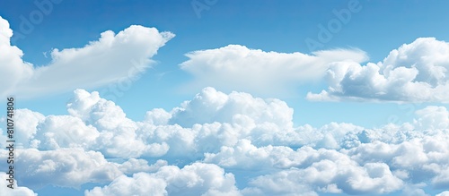 Background copy space image of a sky adorned with scattered white clouds