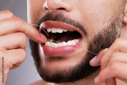 Man  cleaning and teeth with floss in studio for oral hygiene  mouth care and fresh breath. Male person  morning routine and hand with dental product for gum health  protection and cavity prevention