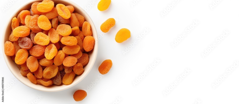 Fotografía Copy space image of a top view bowl filled with dried apricots on a white backgr