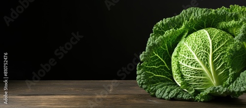 Organically grown savoy cabbage on a black wooden table captured in a copy space image photo