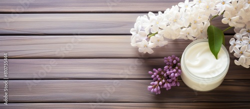 A bright wooden table background showcasing cosmetic creams and a beautiful white lilac blossom Copy space image