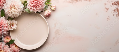A festive table is set with a white plate and cutlery accompanied by a beautiful floral arrangement on a powdery background The image is captured in a flat lay style providing enough space for additi