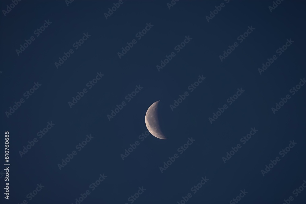 Moon rising over dark hills in night sky Moon rising over dark hills in night sky