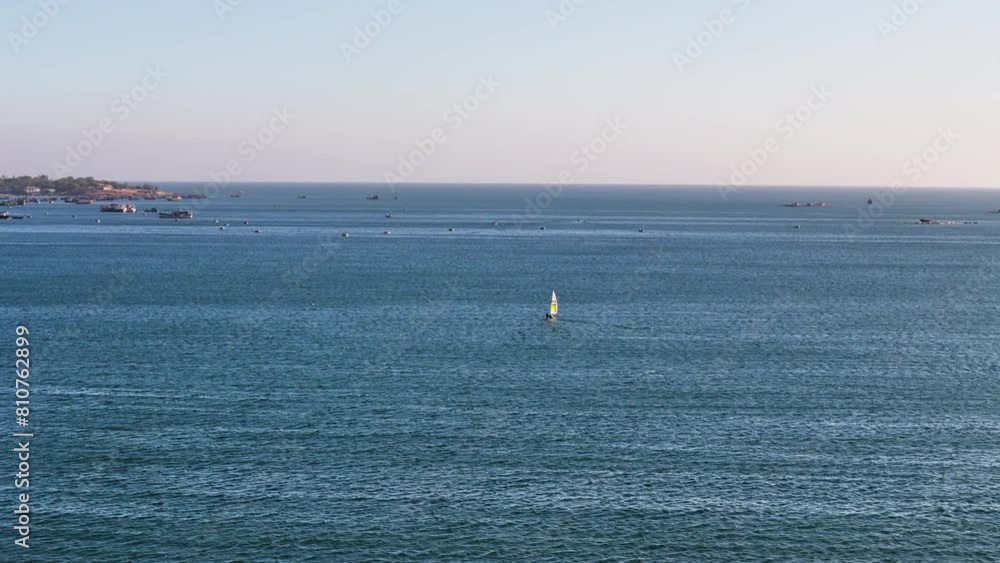 Small Sailboat Isolated Over Mui Ne Bay In Phan Thiet (South East Coast), Vietnam; Wide Aerial Drone Shot. Small Sailboat Isolated Over Mui Ne Bay In Phan Thiet (South East Coast), Vietnam; Wide Aerial Drone Shot.