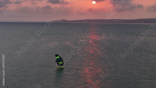 Windsurfer Wing Foiling (Winging) Across A Pink Sunset Sky In Mui Ne Bay, Phan Thiet, Vietnam. photo