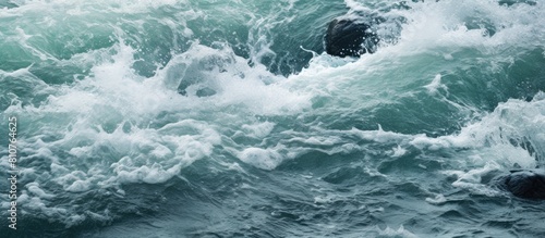 A close up copy space image of frothy water formed as a stream cascades