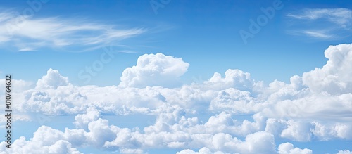 Background copy space image of a sky adorned with scattered white clouds