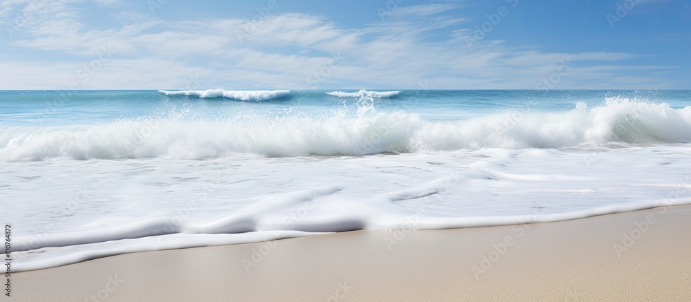 Copy space image of white foam waves crashing onto the shore of the beach