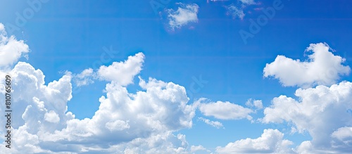 Sunny day with a clear blue sky adorned by white fluffy clouds offering ample copy space for images
