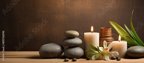 A serene arrangement of candles and spa stones on a wooden backdrop creates a captivating copy space image