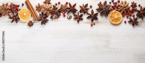 Fototapeta Naklejka Na Ścianę i Meble -  Top view of a Christmas tree crafted from aromatic spices against a backdrop of white wood with ample copy space for additional elements