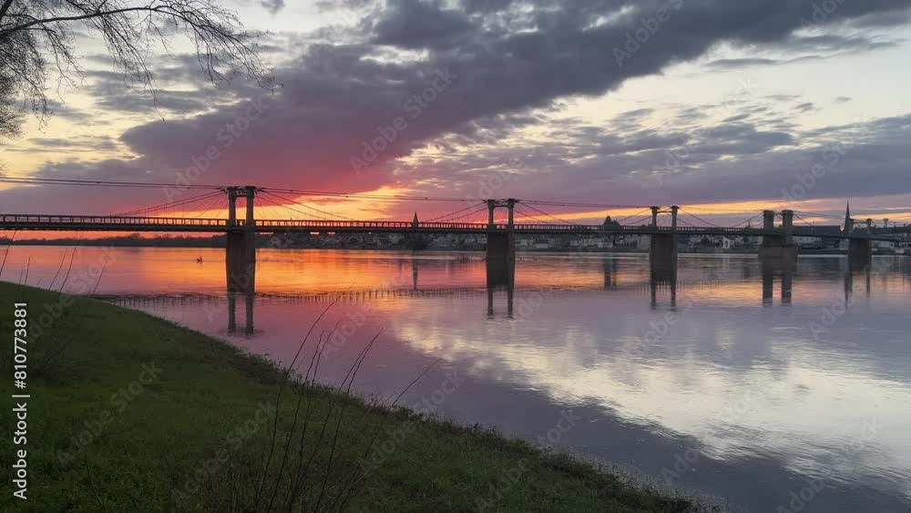 River Loire slowly moving under an old bridge with red sunset behind. River Loire slowly moving under an old bridge with red sunset behind.