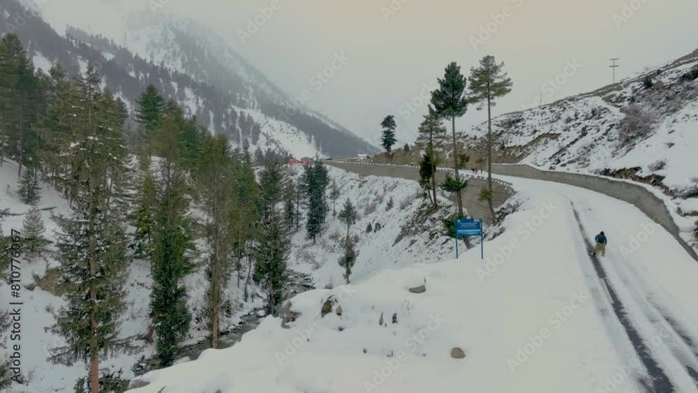 Aerial Rising Shot From Side Of Snow Covered Road In Naltar Valley, Gilgit Aerial Rising Shot From Side Of Snow Covered Road In Naltar Valley, Gilgit