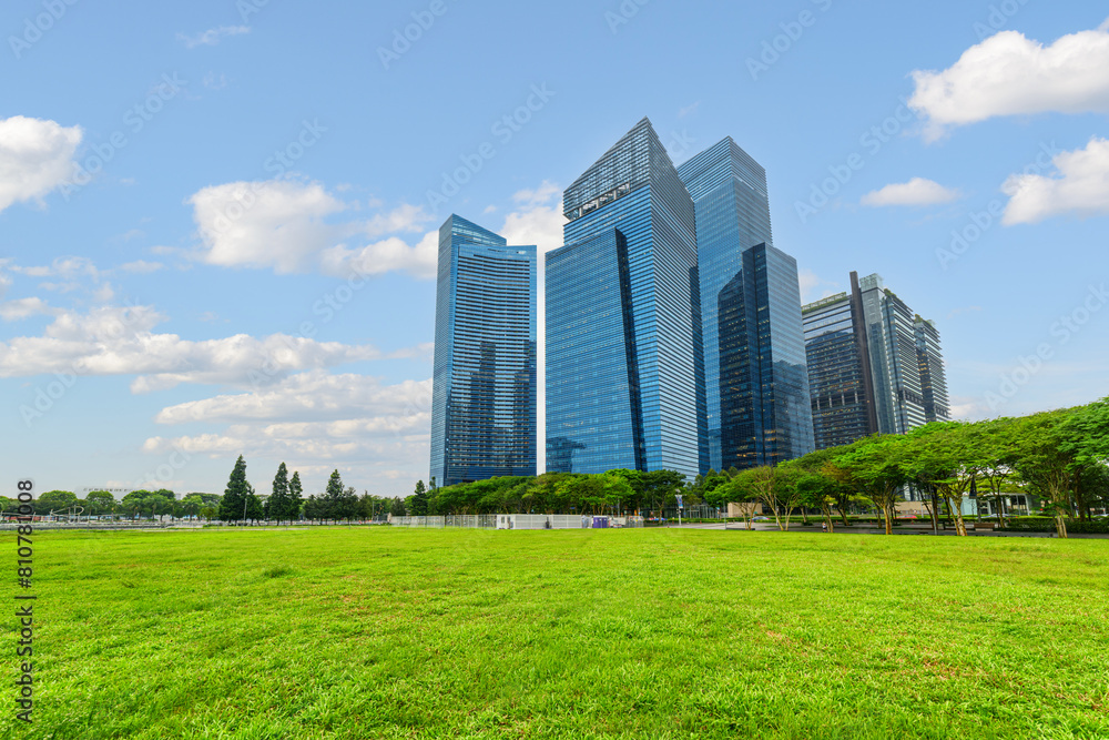 View of skyscrapers at downtown across green lawn in Singapore View of skyscrapers at downtown across green lawn in Singapore