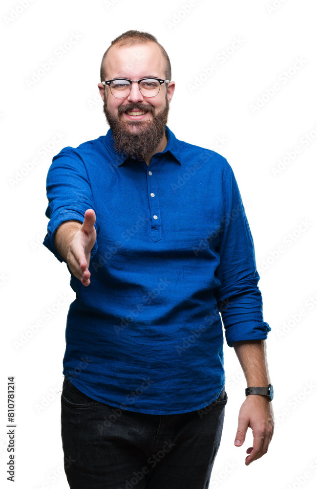 Young caucasian hipster man wearing glasses over isolated background smiling friendly offering handshake as greeting and welcoming. Successful business. Young caucasian hipster man wearing glasses over isolated background smiling friendly offering handshake as greeting and welcoming. Successful business.