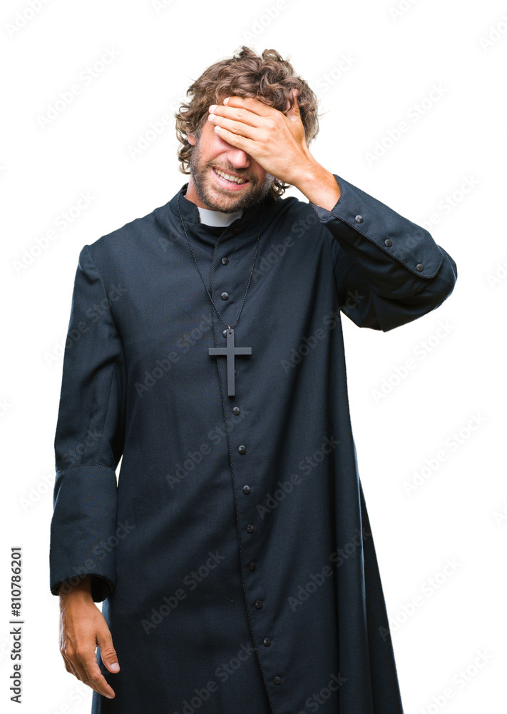 Handsome hispanic catholic priest man over isolated background smiling and laughing with hand on face covering eyes for surprise. Blind concept. Handsome hispanic catholic priest man over isolated background smiling and laughing with hand on face covering eyes for surprise. Blind concept.